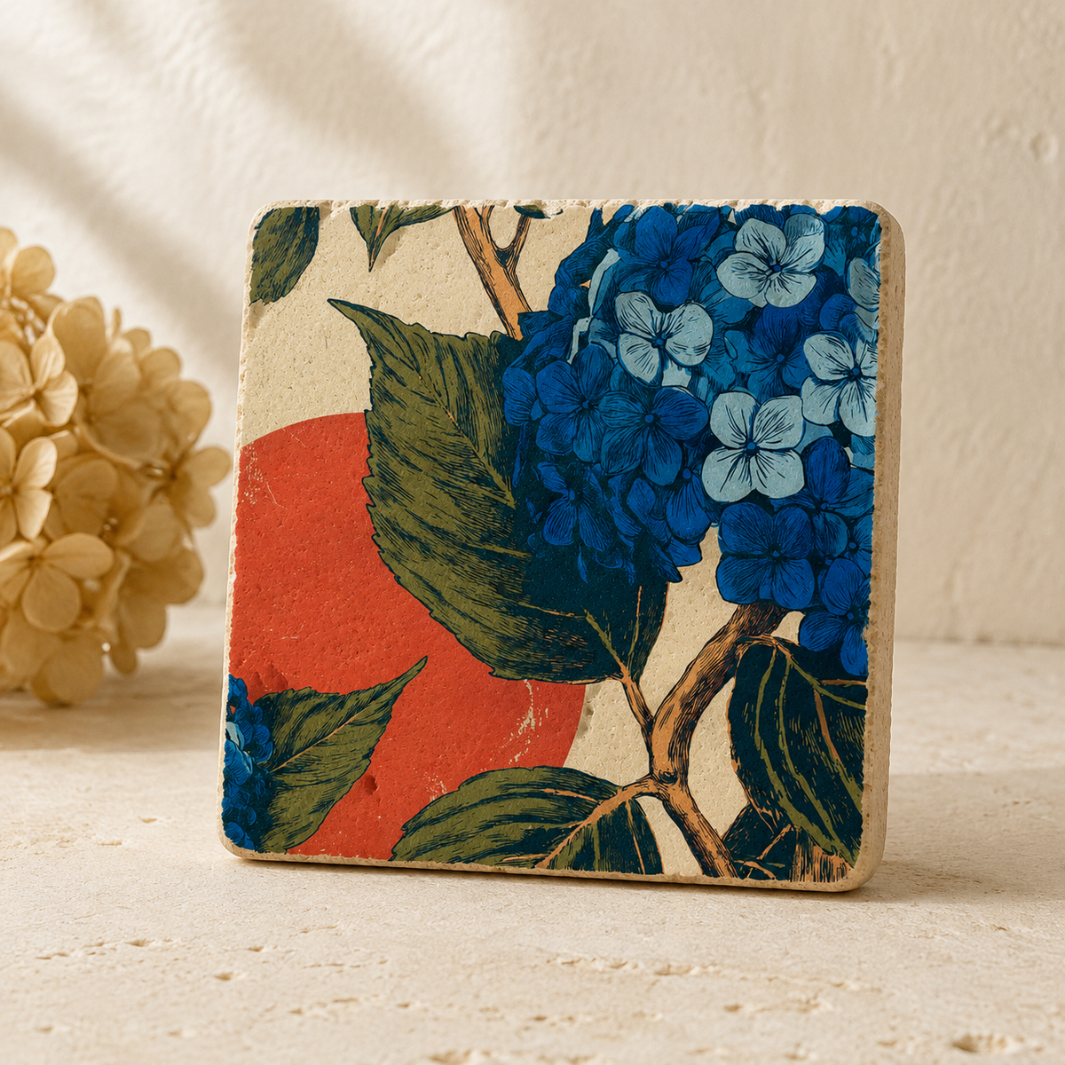 Hortensien im Abendrot – Kleines Kunstwerk aus Travertin mit blauer Hortensienblüte, olivgrünen Blättern und korallrotem Farbkreis, UV-Direktdruck, 10x10 cm
